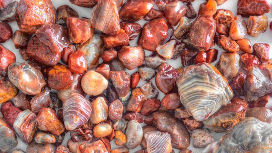 A group of small, red, orange, and cream-striped stones.