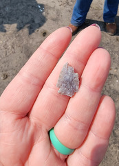 A small piece of worked stone in a hand. 