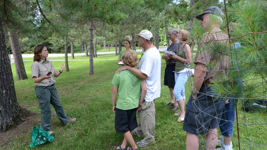 A naturalist gives a presentation to a group outdoors. 