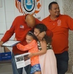 Kevin Washington receives certificate from daughters Arianna and Samara.  