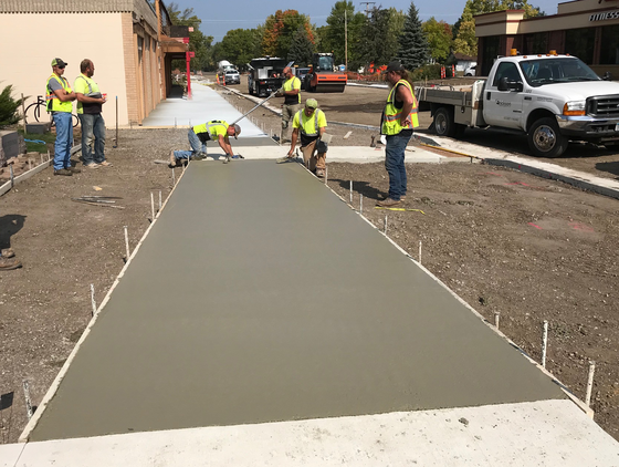 Crews pour concrete sidewalks within the pedestrian downtown boulevard Sept. 22. Photo by MnDOT
