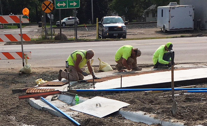 Crews install textured dome sheets on walk approaches Sept. 17 at Hwy 24/Hwy 55. Photo by MnDOT