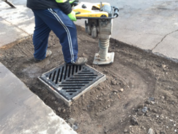 Crew member compressing the soil around a catch basin during construction to prevent future settling and heaving. 