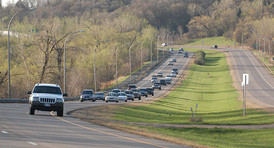 Stream of cars driving on road in Greater Minnesota.