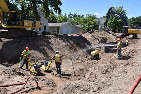 Crews compact the dirt in the trench where utility work was completed on Highway 87 in Frazee