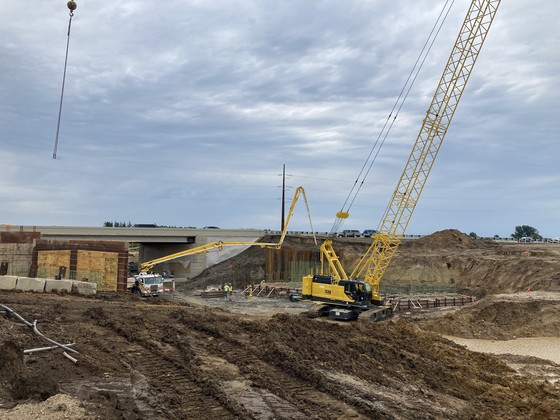 Photo of construction workers pouring concrete on southbound Highway 52 bridge abutment at Hader.