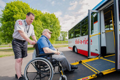 Man in wheelchair being loaded on bus