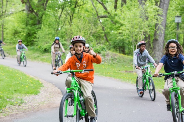 Children riding their bikes in a wooded forest biking trail