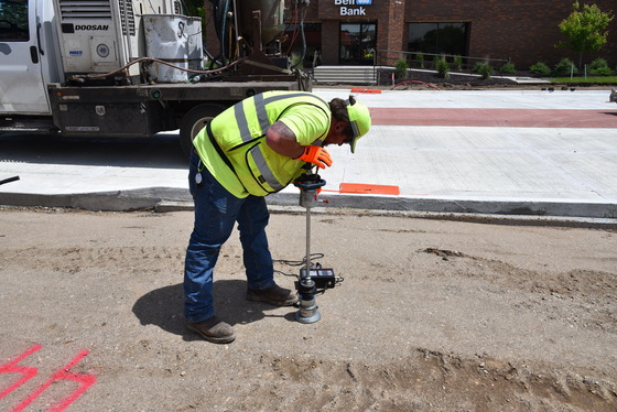 MnDOT inspector checks sidewalk grading compaction  