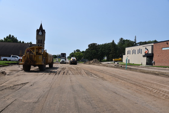 Crews grade the roadway in front of the school