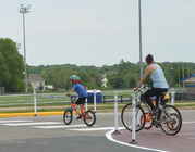 Two kids and parent biking at a crosswalk