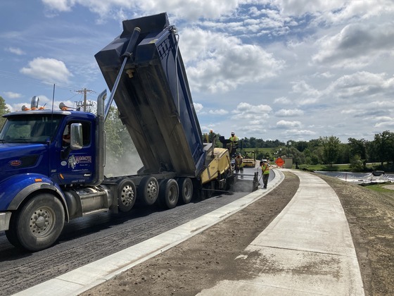 Photo of dump truck and asphalt paving crew in Mantorville, Minnesota.