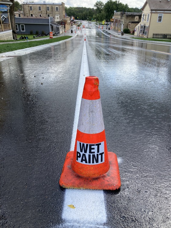 Photo of pylon that says wet paint on a freshly striped portion of Highway 57 in Mantorville, Minnesota on August 16, 2024.