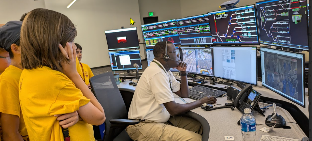 Students observe a train controller at Metro Transit