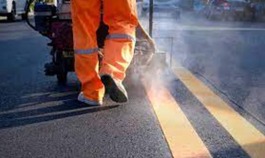 Maintenance worker applies pavement marking