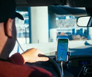 Man drives car with smartphone in holder for GPS directions