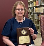 Sheila Hatchell holding award plaque