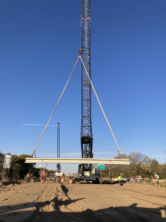 Photo showing construction crane lifting a bridge beam at the Cedar River on Interstate 90 in Austin, Minnesota. 