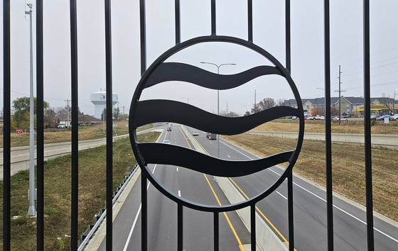 Decorative bridge element of river on bridge railing at School St.