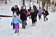 Group of elementary students walking to school on the snowy sidewalks.