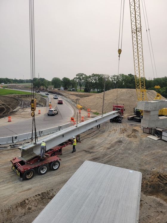 Highway 52 bridge beam is rigged to a crane by workers to ready it for placement.