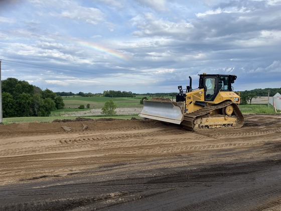 Construction equipment with a rainbow in the background