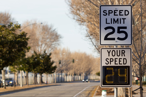 A local road shows a posted "Speed Limit 25" mph sign with a digital reading of "Your Speed 24" mph below it.