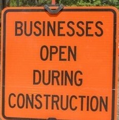 Sign that says businesses open during construction