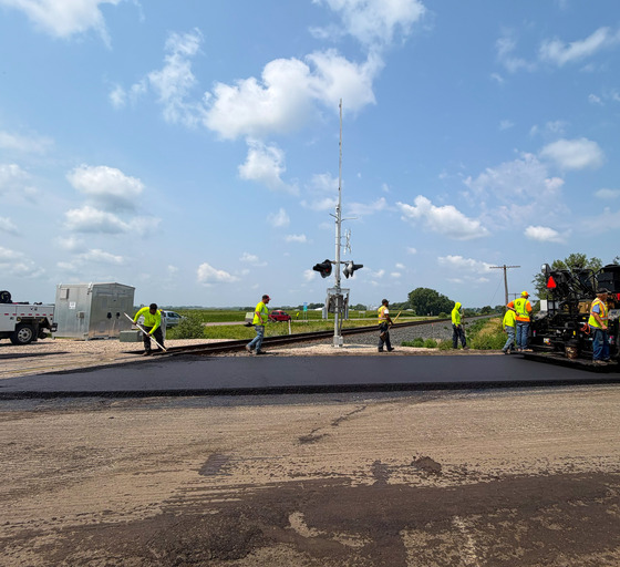 Crews connect paving to railroad crossing near Lowry