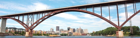 The Smith Avenue High Bridge frames the downtown St. Paul, MN skyline with the water of the Mississippi River in the foreground.