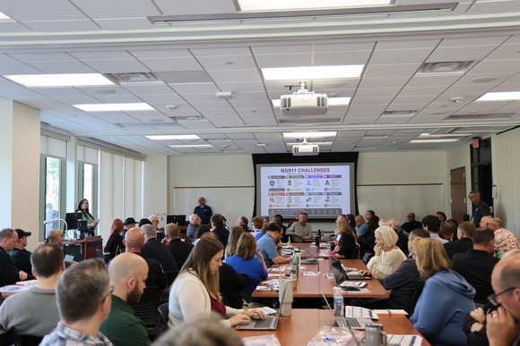 Photo of people in a room listening to presentation on NG911