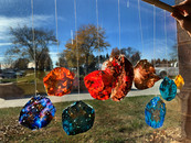 Handmade planets hanging by string against a window