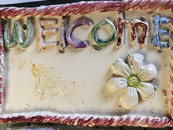 Glazed ceramic sign that reads Welcome