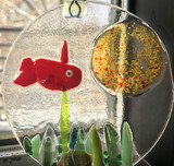 Circular piece of glass with a red fish