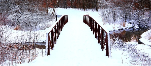 A snow-covered bridge over a creek