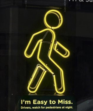 Yellow neon-sign of a person walking