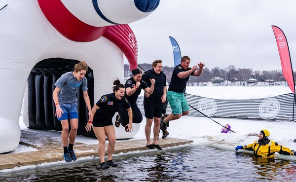 Four people jump into a lake at a previous Polar Plunge event