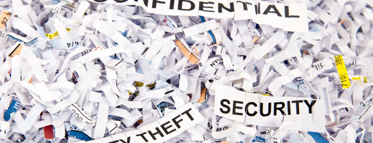 Shredded paper with strips that say "confidential," "security" and "identity theft."