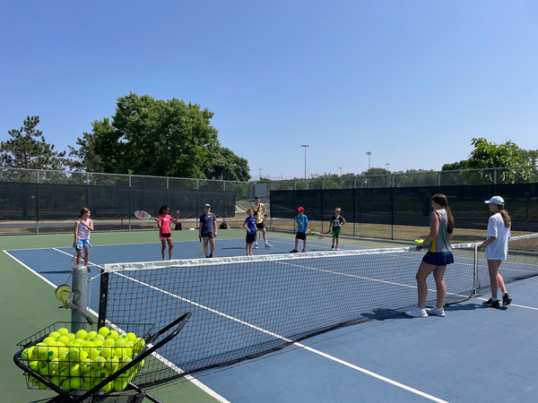 Group of kids learning how to play tennis