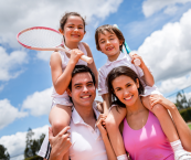 Set of parents holding kids with tennis rackets