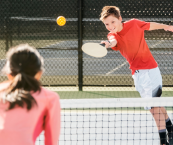 Two kids playing pickleball