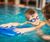 Young boy swimming during a private swim lesson in the pool