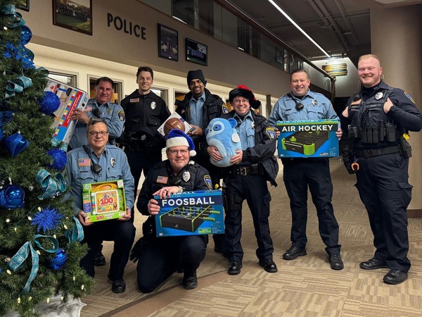 Officers with presents in front of a tree