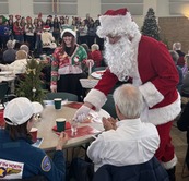 Santa Claus hands out treats to guests at the Senior Center's 2024 Holiday Luncheon.