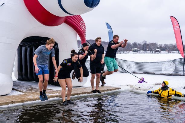 People jumping into Lake Riley at a previous plunge event
