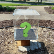 Large, glass box with question mark inside