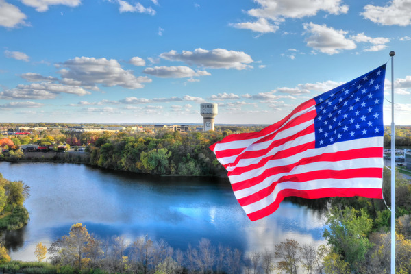 USA flag flying with Eden Prairie water tower in the background