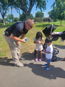 An officer speaks with two children
