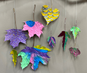 colorful, painted fall leaves strung on a branch