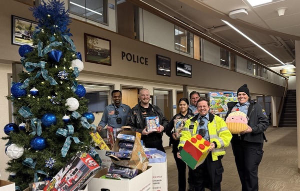 Officers in front of christmas tree with toys